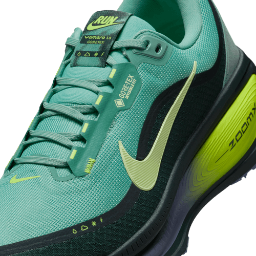 Et nærbillede af Nike Vomero 18 Gore-Tex, Herre, i Seaweed/Barely Volt-Cannon-Volt viser den teksturerede overdel, den polstrede sål, GORE-TEX-mærket og den gule swoosh - ideel til komfort og beskyttelse i al slags vejr.
