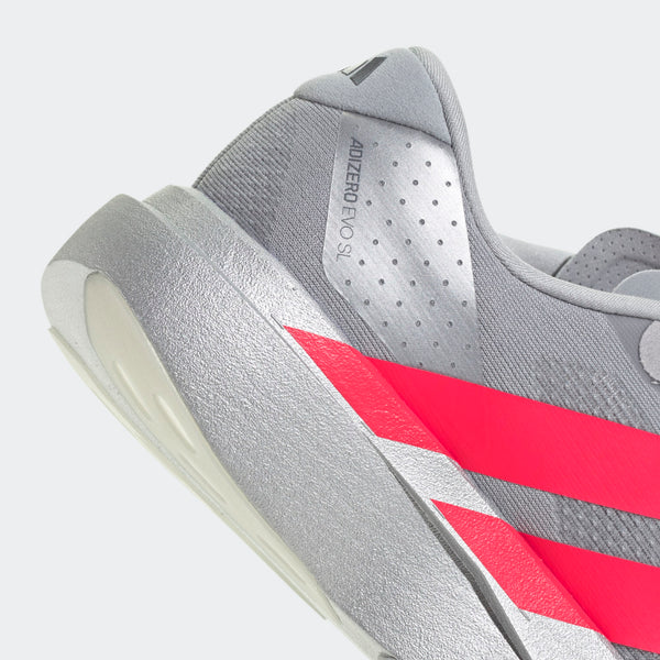 Nærbillede af Adidas Adizero Evo SL løbesko til herrer i Silvmt/Lucred/Ironmt, der viser lyserøde diagonale striber, perforerede detaljer, "ADIZERO EVO 1"-tekst, en tyk tekstureret sål og Lightstrike Pro-støddæmpning.