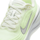 Nærbillede af en Nike Vomero Plus Dame løbesko i Sail/Metallic Silver-Barely Volt med grå Swoosh, hvide snørebånd, tekstureret mesh-overdel og et responsivt ReactX-mellemsål for øget komfort.