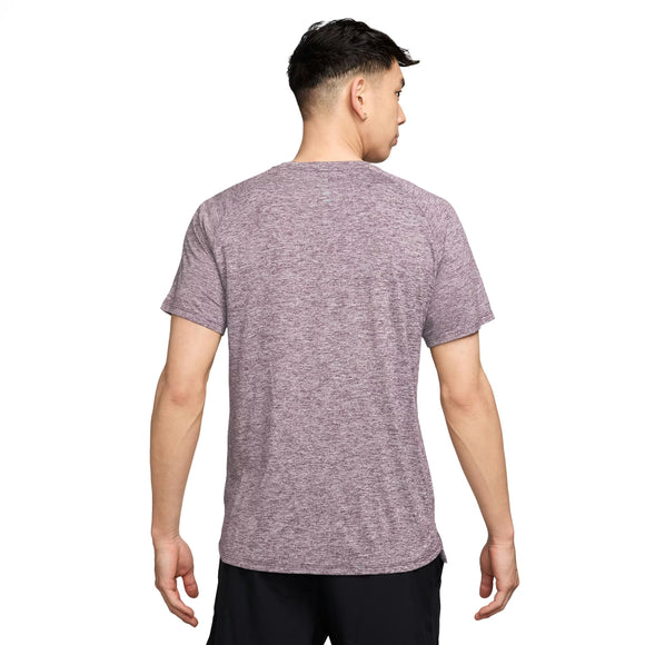 En mand ses bagfra i en Nike Stride SS Running Top til mænd, Lt Violet Ore/Reflective Silver, og sorte shorts, der fremhæver denne fugttransporterende træningstrøje mod en almindelig hvid baggrund.