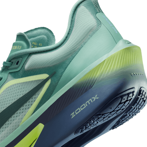 Et nærbillede af hælen og sålen på Nike Zoom Fly 6 Herre i Cannon/Seaweed-Light Silver-Cobalt Bliss viser "ZOOMX" på mellemsålen med gradientfarver og gulblå accenter for et dynamisk look.