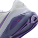Nærbillede af hælen og sålen på Nike Structure 26 Dame i Summit White/Wild Grape-Amethyst Tint med rødt logo på sålen, strukturerede grebsriller og pålidelig stabilitet.