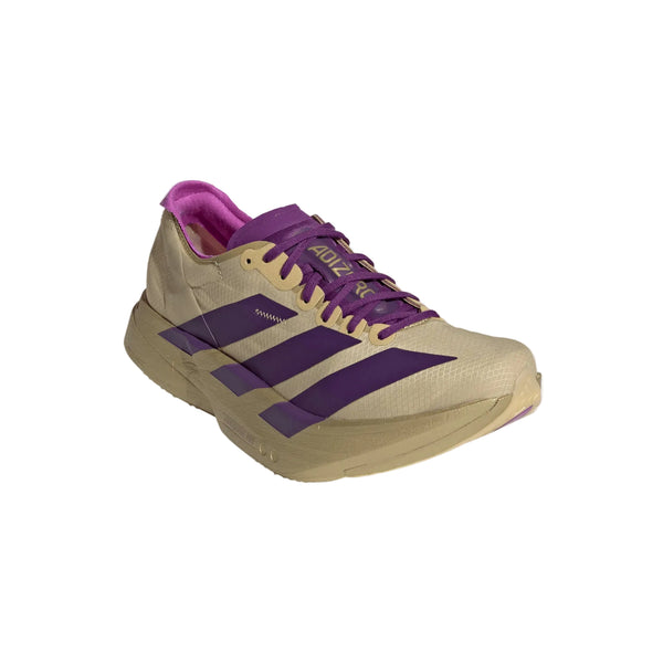 Adidas Adizero Adios Pro 4 til kvinder i Sand/Ricpur/Goldmt har lilla detaljer på striberne, snørebåndene og foringen, her set fra forsiden mod en almindelig hvid baggrund.