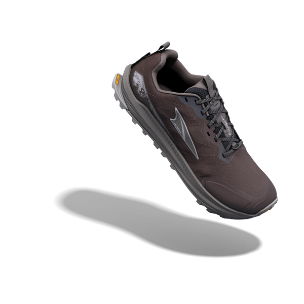 Altra Lone Peak 9+ til mænd i farven Chocolate Torte/Silver er afbildet svævende over en ensfarvet hvid baggrund, hvor den kaster en blød skygge. Denne sportssko har sorte snørebånd, en robust sål og et reflekterende logo på siden.