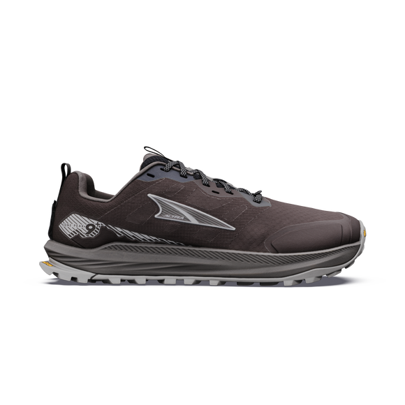 Altra Lone Peak 9+ Herre i farven Chocolate Torte/Silver er en mørkegrå trailsko med sorte og grå snørebånd, et sølvfarvet logo på siden, en tyk, robust sål, der giver godt greb, et lavt snit og diskrete grafiske detaljer ved hælen.