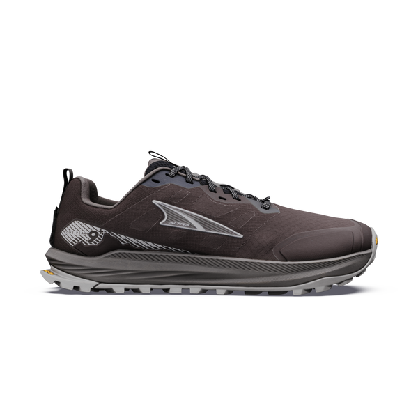 Altra Lone Peak 9+ Herre i farven Chocolate Torte/Silver er en mørkegrå trailsko med sorte og grå snørebånd, et sølvfarvet logo på siden, en tyk, robust sål, der giver godt greb, et lavt snit og diskrete grafiske detaljer ved hælen.