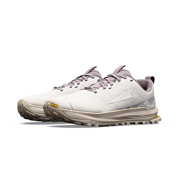 Altra Lone Peak 9+ trail-løbeskoene til kvinder i farvekombinationen Perfectly Pale/Pearl/Bark har tykke, strukturerede gummisåler, snørelukning og et logo på siden, der fremstår på en hvid baggrund.