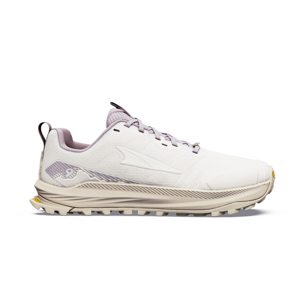 Set fra siden har Altra Lone Peak 9+ Dame i farvekombinationen Perfectly Pale/Pearl/Bark en lys beige overdel, en tyk, struktureret sål, et lyselilla inderfor og et diskret logo på siden, der fremstår tydeligt på den ensfarvede hvide baggrund.