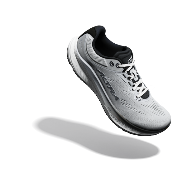 En Altra Torin 9 herreløbesko i farvekombinationen Ultimate Grey/Black/Vapor Blue, med Zero Drop-design, er afbildet svævende i luften på en lys baggrund med sin skygge nedenunder.