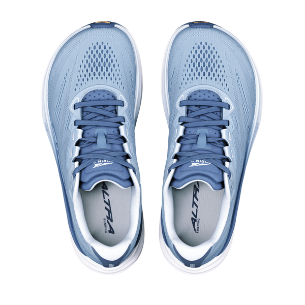 Et par Altra Torin 9 Dame-løbesko i farvekombinationen Windward Blue/White/Dark Denim, med overdel i mesh, mørkeblå snørebånd og Zero Drop-teknologi. ALTRA-logoet er placeret på tungen og indersålen. Set ovenfra på en hvid baggrund.