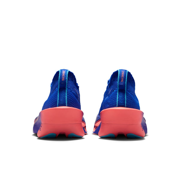 Et par Nike Alphafly 3 herreløbesko i farvekombinationen Racer Blue/White-Atomic Pink set bagfra, der fremviser en strålende blå strikket overdel med en markant lodret turkis stribe ned ad midten samt tykke, lyserøde og lilla såler med et karakteristisk bølget mønster. Disse innovative sko er designet til seriøse løbere og kombinerer banebrydende ydeevne med iøjnefaldende stil.