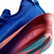 Nærbillede af hælen og sålen på Nike Alphafly 3, Herre i farvekombinationen Racer Blue/White-Atomic Pink – en maratonløbesko i premium-kvalitet til mænd – der fremviser den tykke, buede røde og lilla mellemsål med turkisgrønne grebsdetaljer på undersiden, set på en hvid baggrund.