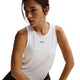 En kvinde med mørkt hår, der er trukket tilbage, bærer Nike Nk One Classic Df Tank til kvinder i hvid/sort med et lille sort logo på brystet, mens hun står på en almindelig hvid baggrund.