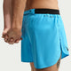 Nærbillede af to personer, der holder hinanden i hånden. Den ene har Nike AeroSwift 4" løbeshorts til mænd med underbukser i farven Lt Current Blue/Black på, med sort linning og logo; disse shorts byder på både komfort og stil. En del af deres ben og hænder er synlige.