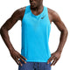 En person iført en Nike AeroSwift løbetrøje til mænd i farven Lt Current Blue/Black med et sort logo på brystet, kombineret med blåstribede shorts, står med hænderne i siden foran en hvid baggrund.