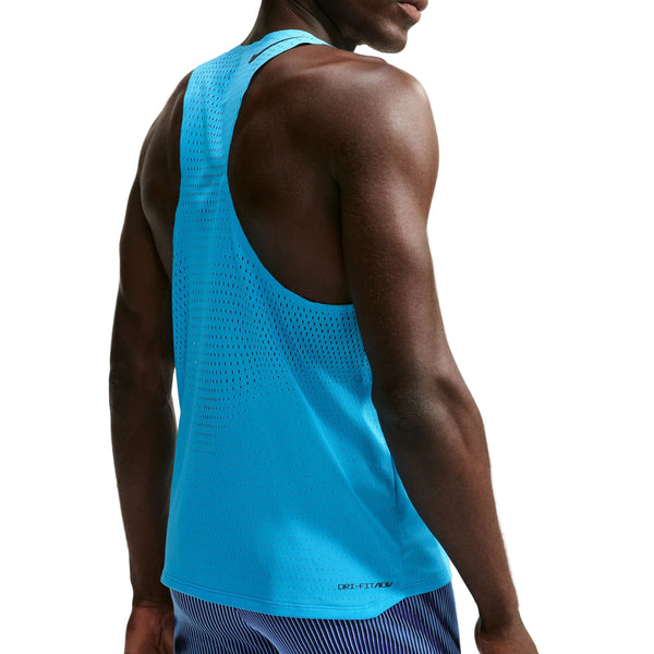 Der ses en person set bagfra på en hvid baggrund, iført en Nike AeroSwift løbetrøje, herre, Lt Current Blue/Black med perforeret stof og lilla stribede shorts.