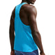 Der ses en person set bagfra på en hvid baggrund, iført en Nike AeroSwift løbetrøje, herre, Lt Current Blue/Black med perforeret stof og lilla stribede shorts.
