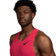 En mand iført en ærmeløs Nike AeroSwift løbesinglet til herre i farvekombinationen Fusion Red/Black poserer foran en hvid baggrund og kigger let til siden. Denne løbesinglet til herre er designet med avanceret Dri-FIT-teknologi, der hjælper med at holde dig kølig og tør under din træning.