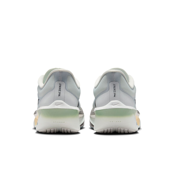 Et par Nike Zoom Fly 6 til mænd i farvekombinationen Pure Platinum/Dark Obsidian-Grey Fog, set bagfra, fremstår i lysegrå og hvide nuancer med ZoomX-skumsåler med grønne detaljer og synlige Nike-logoer på hælene på en hvid baggrund.