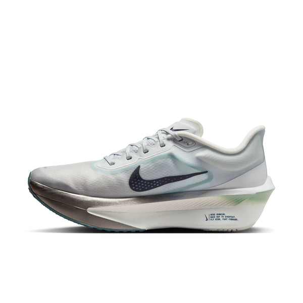 Et billede set fra siden af Nike Zoom Fly 6, Herre i farvekombinationen Pure Platinum/Dark Obsidian-Grey Fog viser en grå og hvid sko med et sort Swoosh-logo, en gennemsigtig overdel, tekst på mellemsålen, grønne detaljer på hælen og en tyk, buet ZoomX-skum-sål.