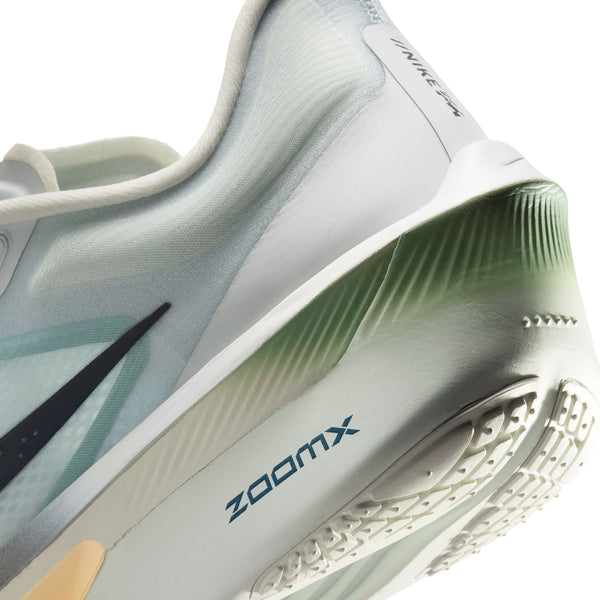 Nærbillede af hælen og ydersålen på Nike Zoom Fly 6, Herre (Pure Platinum/Dark Obsidian-Grey Fog), der fremhæver den grønne og hvide sål med farveovergang, ZoomX-skum, ZoomX-logoet og en del af Nike-swooshen.