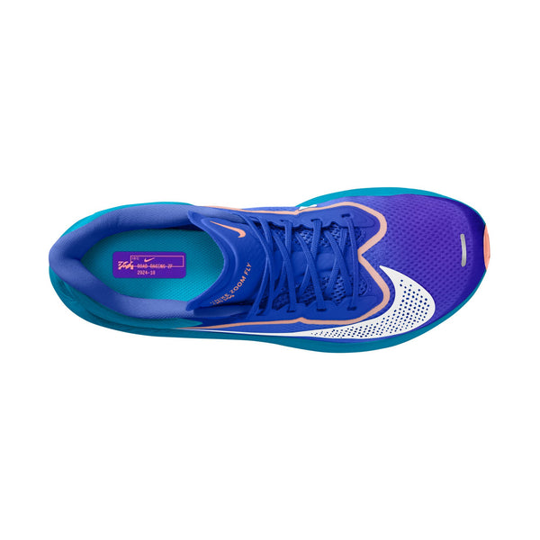 Set ovenfra har Nike Zoom Fly 6, Herre i farvekombinationen Racer Blue/White-Blue Lightning en blå overdel med lilla snørebånd, en hvid, perforeret tå, turkise detaljer på siderne og lyserødt logo. Skoen er udstyret med responsiv ZoomX-skumstøddæmpning.