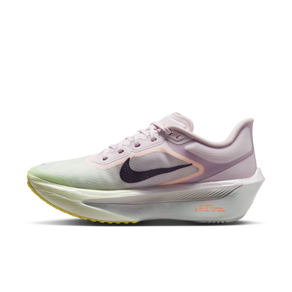 Nike Zoom Fly 6 Dame i farvekombinationen Bleached Lilac/Purple Dynasty-Volt Tint har et lyslilla og hvidt design, en markant sort Swoosh, en pastellgrøn tå, halvgennemsigtige overlag, en tyk hvid sål med ZoomX-skum og gule detaljer på ydersålen.