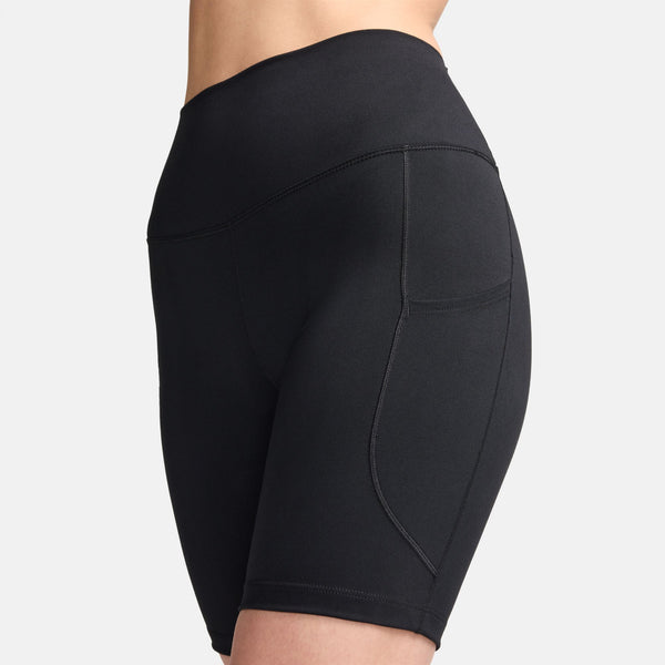En model er iført Nikes One High-Waisted 8" Biker Shorts With Pockets, Dame, i sort/sort, med synlige sidesømme og en praktisk sidelomme, vist fra taljen til midt på låret mod en ensfarvet hvid baggrund.