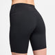 En person ses bagfra iført Nikes One High-Waisted 8" Biker Shorts With Pockets til kvinder i sort. Shortsene har synlige syninger, logo i linningen, længde midt på låret og praktiske lommer.