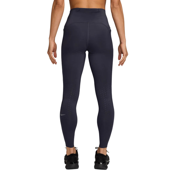 Der ses en person set bagfra, iført Nike Swift High-Waisted 7/8 løbetights med lommer i farven Gridiron/Reflective Silv og sorte sneakers. Armene hænger afslappet ned langs siden, mens der ses små ventilationshuller og diskrete refleksdetaljer på underbenene af tightsene.