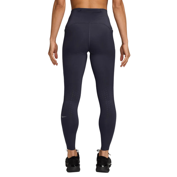 Der ses en person set bagfra, iført Nike Swift High-Waisted 7/8 løbetights med lommer i farven Gridiron/Reflective Silv og sorte sneakers. Armene hænger afslappet ned langs siden, mens der ses små ventilationshuller og diskrete refleksdetaljer på underbenene af tightsene.