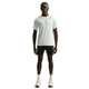 En mand kigger fremad i en Nike Nk Dfadv Aroswft Ss Top, Herre, Summit White/Black med sorte Nike-shorts, hvide sokker og sneakers samt mørke solbriller. T-shirten er udstyret med Nikes avancerede Dri-FIT ADV-teknologi, der giver komfort.