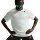 En mand i Nike Nk Dfadv Aroswft Ss Top, Herre, Summit White/Black og sorte Nike-shorts poserer med spejlende solbriller og hænderne på hofterne mod en hvid baggrund for at fremhæve den nyeste løbekollektion.
