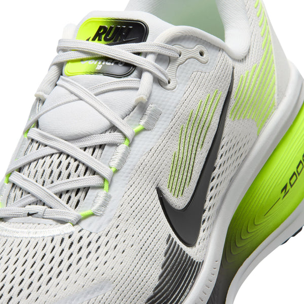 Nærbillede af Nike Vomero 18, Herre i farvekombinationen Photon Dust/Black-Volt – en hvid herreløbesko med neongule og grønne detaljer, et sort Nike Swoosh-logo og teksten »RUN« på tungen. Denne sportslige løbesko er fremstillet af mesh-materiale og har hvide snørebånd, der sikrer åndbarhed, støtte og maksimal komfort under hver eneste løbetur.