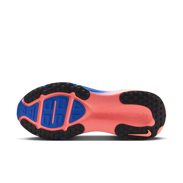 Billedet viser sålen på Nike Vomero 18, Herre i farvekombinationen hvid/sort-racerblå-atomic pink, med en lyserød midterdel, blå og sort slidbane samt strukturerede mønstre, der sikrer godt greb. Ydersålen er udformet med geometriske former og forskellige forhøjede sektioner for maksimal komfort og optimal vejgreb.