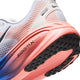 Nærbillede af hælen og sålen på Nike Vomero 18, Herre i farvekombinationen hvid/sort-racerblå-atomic pink, med en mellemsål i lyserød og blå farveovergang samt en sort ydersål med »ZOOMX«-tekst nær hælen. Det karakteristiske Nike Swoosh-logo og de strukturerede grebsdetaljer sikrer maksimal komfort ved hvert skridt.