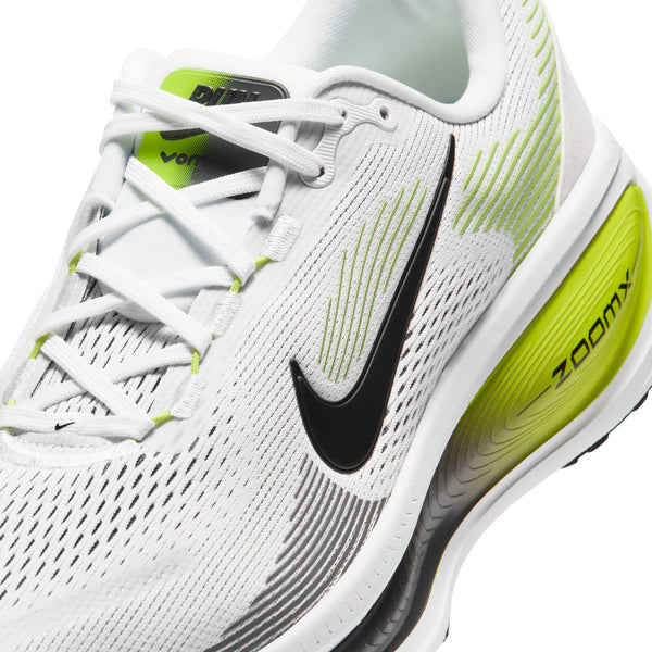 Nærbillede af Nike Vomero 18-løbeskoen til herre i farvekombinationen HVID/SORT-LEMON VENOM-MØRKEGRÅ, med en hvid overdel i mesh med sorte og limegrønne detaljer, et sort Nike Swoosh-logo, hvide snørebånd og teksten »ZOOMX« trykt på den gule hæl med farveovergang. Denne model er designet med detaljerede sømme og maksimal dæmpning for at sikre overlegen komfort under din løbetur.
