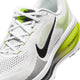 Nærbillede af Nike Vomero 18-løbeskoen til herre i farvekombinationen HVID/SORT-LEMON VENOM-MØRKEGRÅ, med en hvid overdel i mesh med sorte og limegrønne detaljer, et sort Nike Swoosh-logo, hvide snørebånd og teksten »ZOOMX« trykt på den gule hæl med farveovergang. Denne model er designet med detaljerede sømme og maksimal dæmpning for at sikre overlegen komfort under din løbetur.