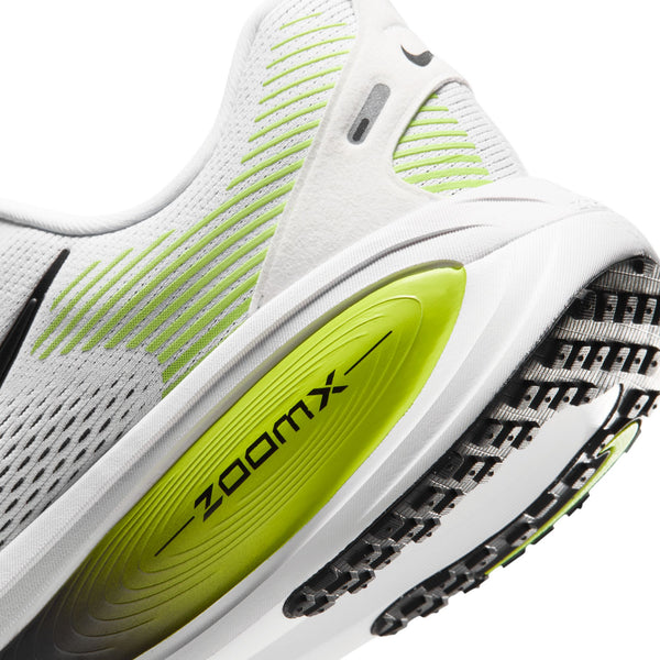 Nærbillede af hælen på en hvid Nike Vomero 18-løbesko med detaljer i sort og citronfarvet, med ordet ZOOMX på mellemsålens side og en struktureret ydersål, der sikrer maksimal dæmpning.