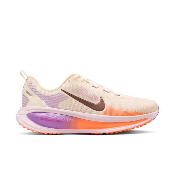 En Nike Vomero 18 dame i farverne Chalk/Tattoo-Pink Foam-Bright Violet med brunt swoosh-logo, lilla og orange detaljer samt "ZoomX"-tryk på siden. Maksimal dæmpning. Skoen er fotograferet på hvid baggrund.