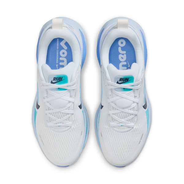 Et billede oppefra og ned af Nike Vomero 18 Dame-løbesko i White/Midnight Navy-Blue Fury med blå detaljer, blågrønne RUN-tags på tungen og indersåler med Vomero i hvid tekst på blå baggrund.