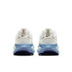 Et par Nike Vomero 18 løbesko til kvinder i farvekombinationen White/Midnight Navy-Work Blue set bagfra, hvor hælen, trækflapperne, Nike-logoerne og de blå, strukturerede ydersåler med maksimal støddæmpning for ekstra komfort fremhæves på en hvid baggrund.