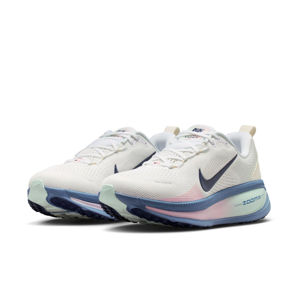 Et par Nike Vomero 18-løbesko til kvinder i farvekombinationen White/Midnight Navy-Work Blue, der er kendt for deres maksimale støddæmpning, er placeret side om side i en vinkel på en ensfarvet hvid baggrund.