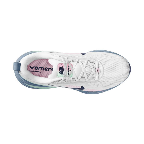 Et billede set ovenfra af Nike Vomero 18 Dame i farvekombinationen White/Midnight Navy-Work Blue viser en hvid mesh-sneaker med snørebånd og et blåt Swoosh-logo, en lyserød indersål med teksten »VOMERO« og »RUN« samt en sål med blågrønne farveovergange, der sikrer maksimal dæmpning.