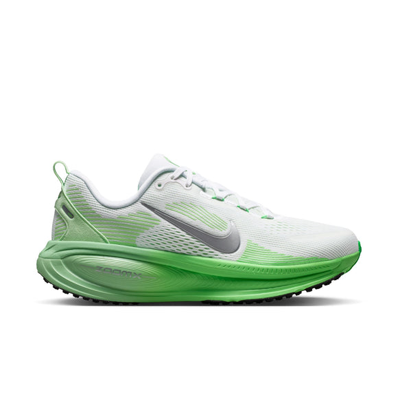 Nike Vomero 18 Dame i farvekombinationen hvid/metalsølv-illusiongrøn har en hvid overdel med livlige grønne detaljer, herunder en grøn sål og farveovergange på hælen. Denne snøresko med et Nike Swoosh-logo i metalsølv er designet til at give maksimal dæmpning og dermed enestående komfort. Vist i profil mod en hvid baggrund er denne model et godt eksempel på både stil og ydeevne.