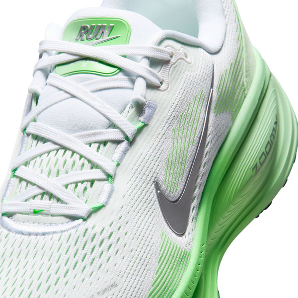 Her er en omskrevet version baseret på dine produktoplysninger: Nærbillede af Nike Vomero 18 dame-løbeskoen i farvekombinationen hvid/metallisk sølv-illusiongrøn, med et metallisk sølvfarvet Swoosh-logo, teksten "RUN" på tungen, hvide snørebånd og ZOOM-logo på den illusiongrønne mellemsål, der sikrer maksimal dæmpning.