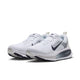 Et par Nike Vomero 18 dame-løbesko i farvekombinationen WHITE/GRIDIRON-PHOTON DUST-PHANTOM, med mørkeblå Swoosh-logoer, en overdel i åndbart mesh og tykke ZoomX-støddæmpede såler, der sikrer maksimal dæmpning. Skoene står side om side og vender let mod venstre.