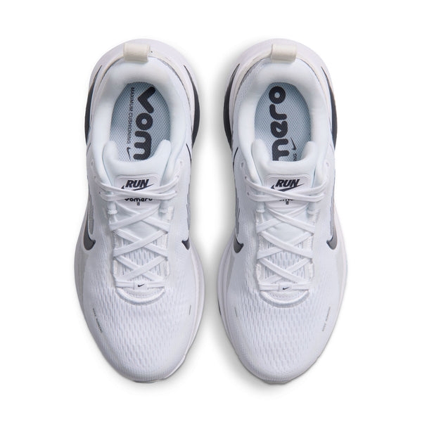 Et par Nike Vomero 18 løbesko til kvinder i farvekombinationen WHITE/GRIDIRON-PHOTON DUST-PHANTOM, set ovenfra. Disse hvide sportssko har hvide snørebånd, sorte Nike-swooshes på siderne og indlægssåler med påskriften »VOMERO« og »RUN«. Modellen er specielt designet til kvinder og giver maksimal dæmpning for optimal komfort under løbeturen.