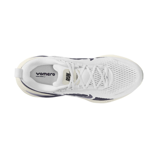 Ovenfra-billede af Nike Vomero 18 løbesko til kvinder i farvekombinationen WHITE/GRIDIRON-PHOTON DUST-PHANTOM, med åndbart mesh-materiale, hvide snørebånd, en trækflap i hælen og teksten »vomero« trykt på indersålen for maksimal dæmpning.
