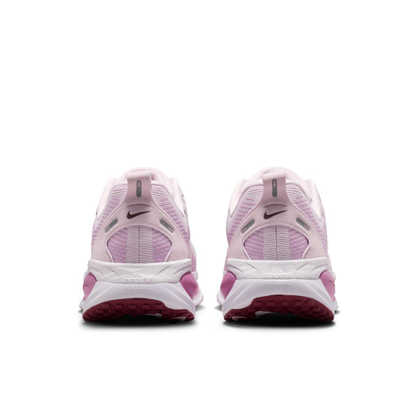 Et par Nike Vomero 18 dame-løbesko i farvekombinationen Bleached Lilac/Pink Smoke-Lt Magenta ses her set bagfra, hvor logoet og såldetaljerne med lilla og lyserøde accenter kommer til sin ret – perfekt til maksimal dæmpning på en hvid baggrund.